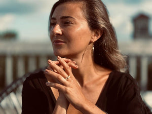 Jewelry artist Alex-Sandrine Nadeau in a contemplative pose, her handcrafted earrings subtly catching the light, embodying the artistic spirit behind her 'What If You Stayed' creations.