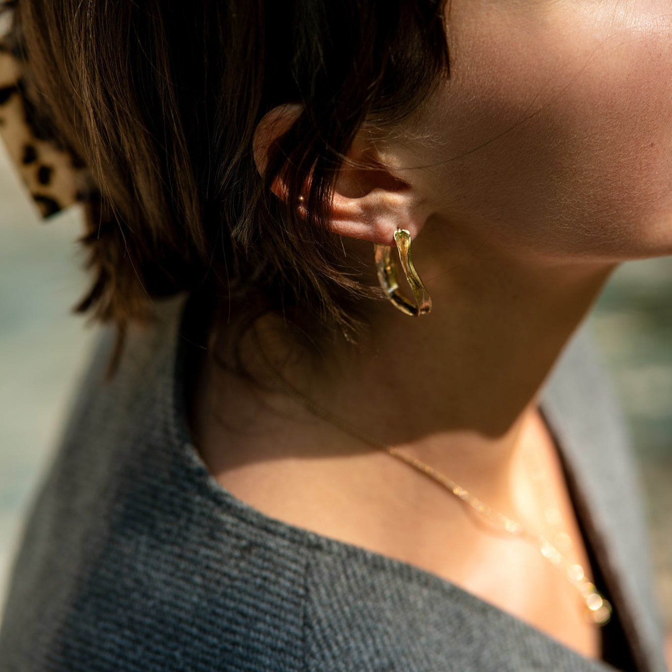 Young Woman with Dark Hair Wearing Gold Ribbon Earrings and Gold Necklace From What If You Stayed Jewelry 