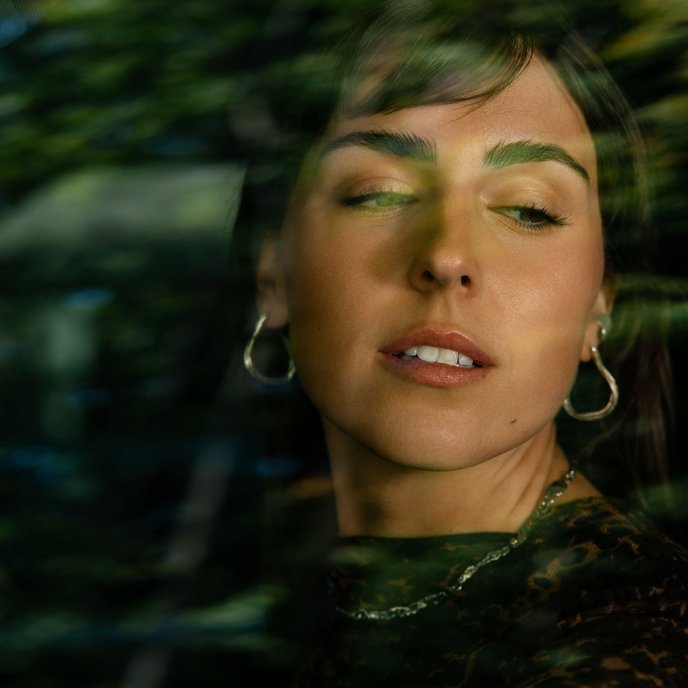 Young Woman with Dark Hair Wearing Silver Ribbon Earrings and Silver Necklace From What If You Stayed Jewelry In Car