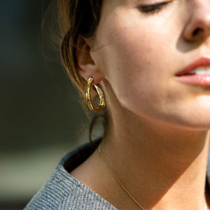 Young Woman with Dark Hair Wearing Gold Ribbon Earrings and Gold Necklace From What If You Stayed Jewelry 