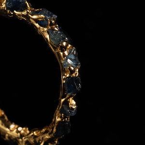 Gold ring with embedded raw stones  made by what if you stayed on a black background