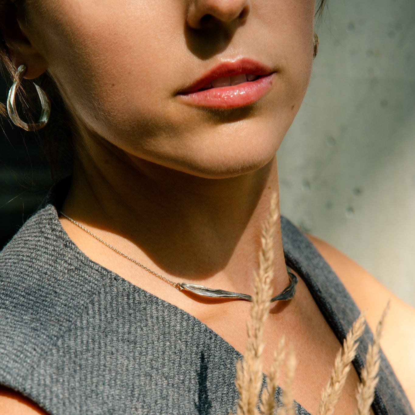 young woman against concrete wall wearing silver jewelry made by what if you stayed