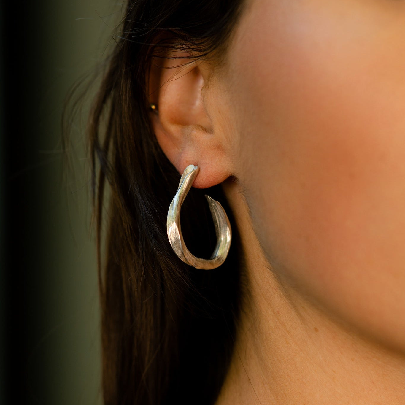 Young Woman with Dark Hair Wearing Silver Ribbon Earrings and Silver Necklace From What If You Stayed Jewelry 